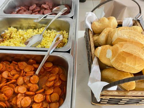 tres bandejas de comida con pan y otros alimentos en Pousada Charle Brown, en Garopaba