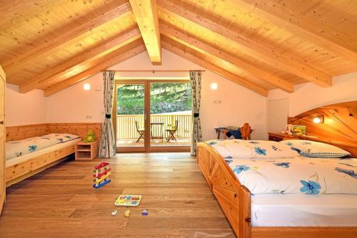 a bedroom with two beds and a wooden ceiling at Planatschhof in Villnoss