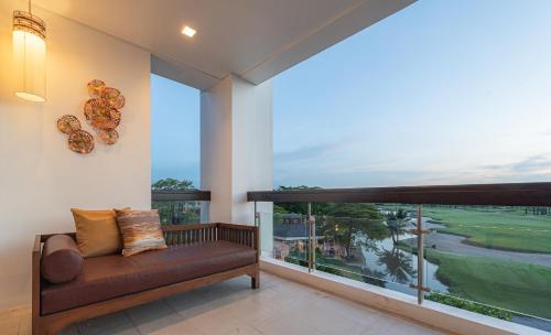 a living room with a couch and a large window at Summit Windmill Golf Suite Hotel at Suvarnabhumi in Bangna