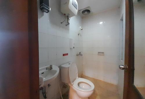 łazienka z toaletą i umywalką w obiekcie The Green Winotosastro Hotel Yogyakarta w mieście Yogyakarta