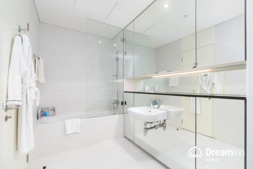 a white bathroom with a sink and a mirror at Dream Inn Apartments - Index Tower in Dubai