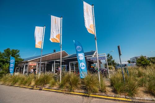 un restaurant avec drapeaux devant un bâtiment dans l'établissement EuroParcs Poort van Zeeland, à Hellevoetsluis