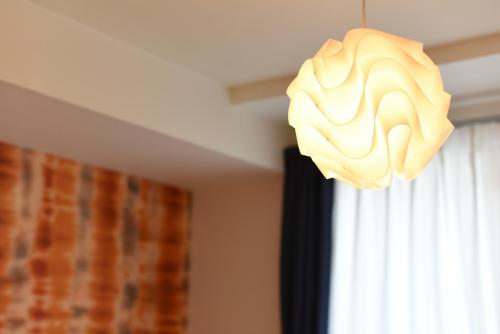 a chandelier hanging from a ceiling next to a window at Northwest IR in Kita-rokujō