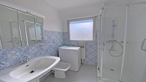 une salle de bain avec un lavabo, des toilettes et une douche dans l'établissement Appartement La Caravelle, à Sainte-Maxime