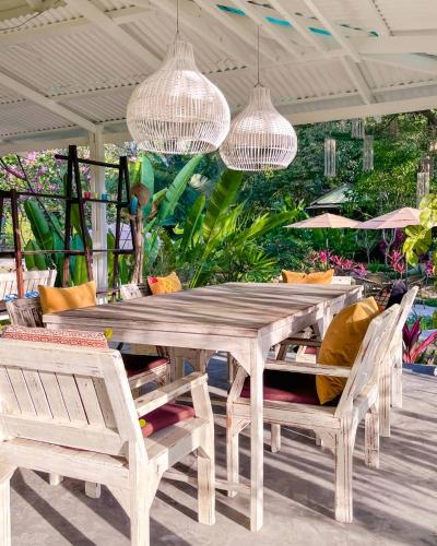 a wooden table and chairs on a patio at Baan Bua Cottage SHA EXTRA PLUS B5510 in Ko Kood