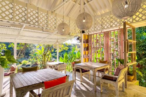 a patio with wooden tables and chairs and plants at Baan Bua Cottage SHA EXTRA PLUS B5510 in Ko Kood