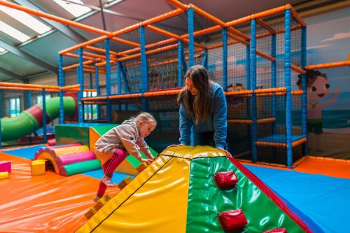a woman and a child playing in an indoor playground at EuroParcs Poort van Zeeland in Hellevoetsluis