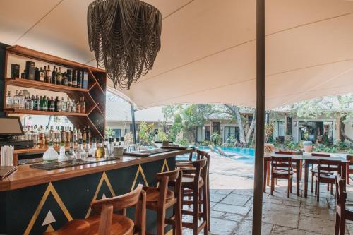 a bar in a restaurant with a pool in the background at Shongwe Oasis in Victoria Falls