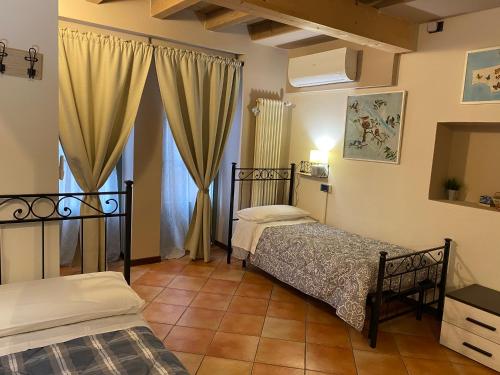 a bedroom with two beds and a mirror at La Casina in Dello