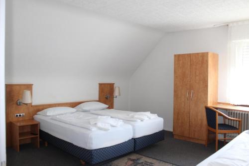 a bedroom with two beds and a table and a chair at Gasthaus zum Ritter in Karlsdorf-Neuthard