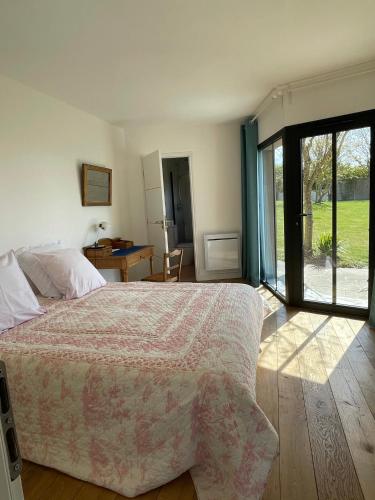 a bedroom with a bed and a sliding glass door at Brise du Large - Maison d'Ault in Ault