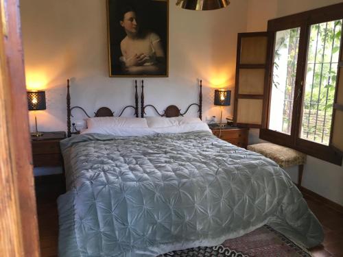 a large bed in a bedroom with two windows at Las Gitanillas, villa with heated pool, La Cala de Mijas in Mijas Costa