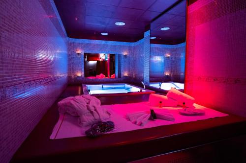 a large bathroom with a tub with pink lighting at Marcantonio Hotel in Giugliano in Campania