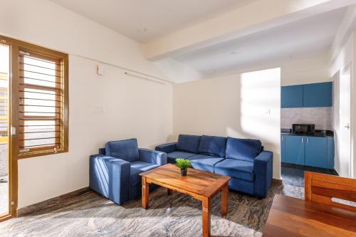 uma sala de estar com duas cadeiras azuis e uma mesa em SPLENDID SHUBHAM SERVICED APARTMENTS em Bangalore