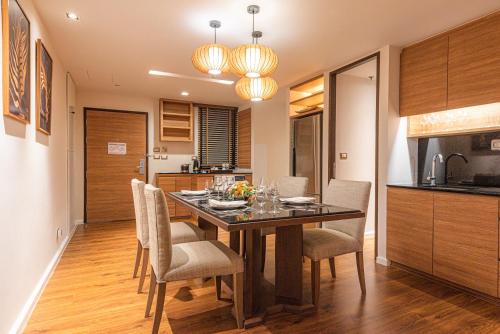 a kitchen and dining room with a table and chairs at Summit Windmill Golf Suite Hotel at Suvarnabhumi in Bangna