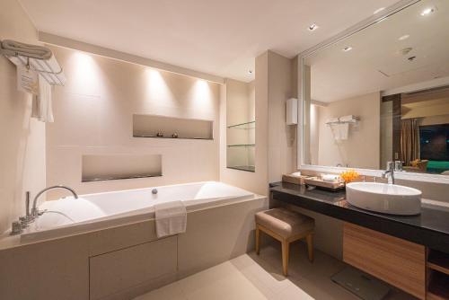 a bathroom with a large tub and a sink at Summit Windmill Golf Suite Hotel at Suvarnabhumi in Bangna