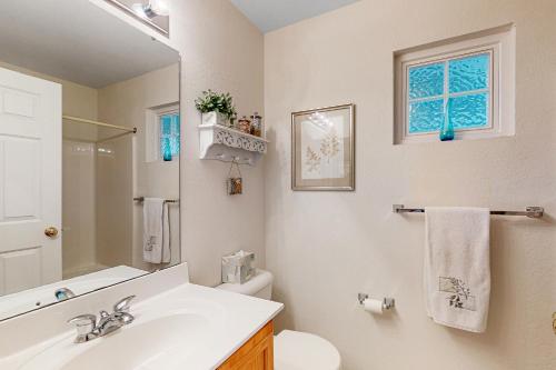 a bathroom with a sink and a toilet and a mirror at South Hampton --- 37923 Greenwich Ln in Ocean View