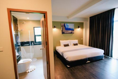 a bedroom with a bed and a bathroom with a shower at Wealth Boutique Hotel Chiang Mai in Chiang Mai