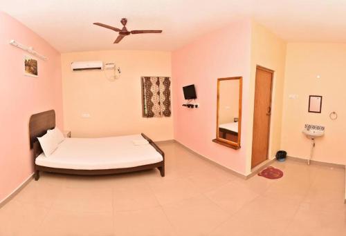 een ziekenhuiskamer met een bed en een spiegel bij Dwarka Residency in Mahabalipuram
