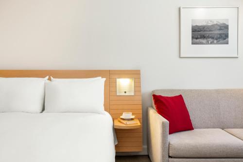 a hotel room with a bed and a couch at Novotel Kayseri in Kayseri