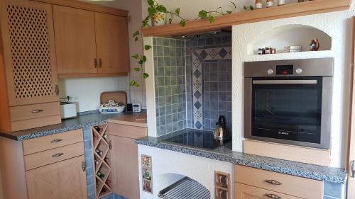 a kitchen with wooden cabinets and a large tv at FEWO Lichtblick in Bautzen