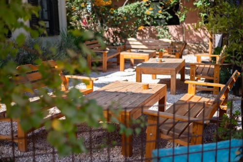 a group of wooden tables and chairs in a yard at Carmey Avdat Farm in Midreshet Ben Gurion