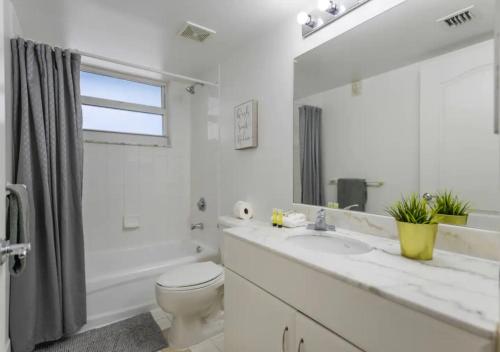 a white bathroom with a toilet and a sink at Attractive 2/2 Condo In Brickell With Pool in Miami