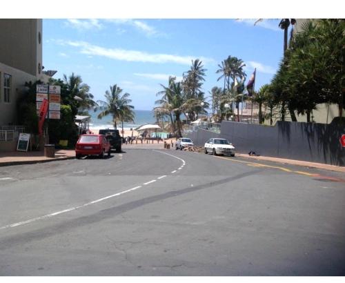 a street with cars parked on the side of a beach at Kingsview 201 in Margate