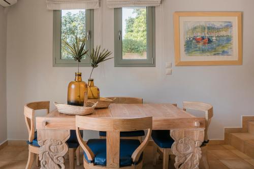 a dining room with a wooden table and chairs at Braunis Horio Villas in Asos