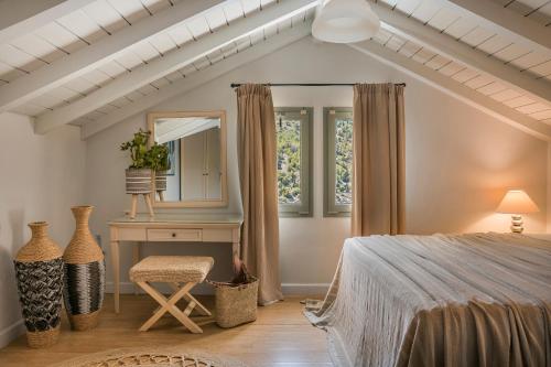 a bedroom with a bed and a desk and a mirror at Braunis Horio Villas in Asos