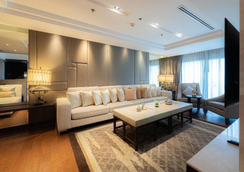 a living room with a couch and a table at Summit Windmill Golf Suite Hotel at Suvarnabhumi in Bangna
