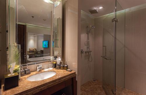 a bathroom with a sink and a shower at Summit Windmill Golf Suite Hotel at Suvarnabhumi in Bangna