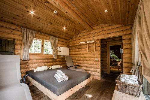 1 dormitorio con 1 cama en una cabaña de madera en Ruster Resort, en Lagundo