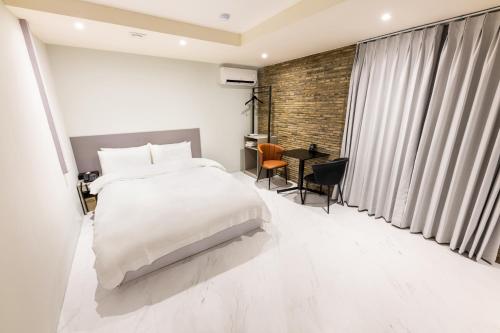 a bedroom with a white bed and a desk at HOTEL LENITH Seomyeon in Busan