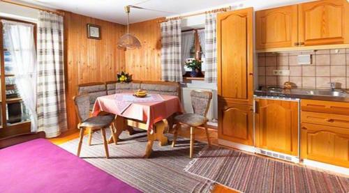 a kitchen with a table and chairs in a room at Ferienwohnung Lippenlehen in Marktschellenberg