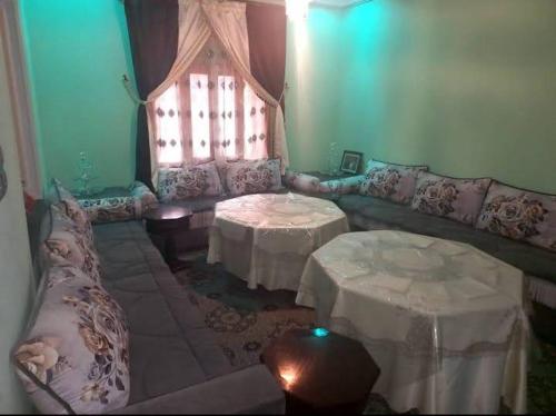 a living room with two tables and a couch at Assounfou in Ouarzazate
