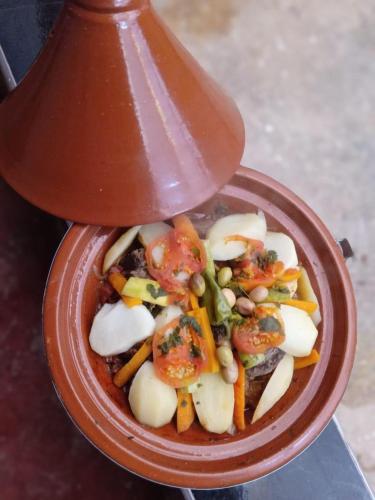 a red bowl of food with tomatoes and vegetables at Assounfou in Ouarzazate
