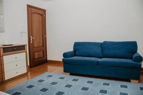 Sofá azul en la sala de estar con alfombra azul en Słoneczny Zakątek Krynica-Zdrój, en Krynica-Zdrój