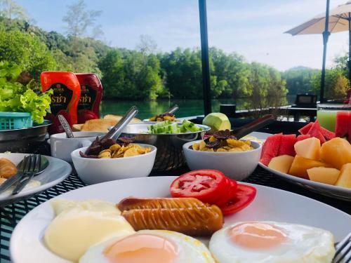 a table topped with plates of eggs and fruit at Bann Klong Jao Homestay in Tok Phrom