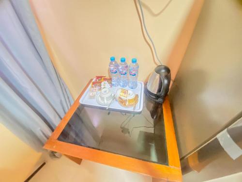 un tavolo con bottiglie d'acqua e un telefono di Villa Matano Sorowako Redpartner a Saroako