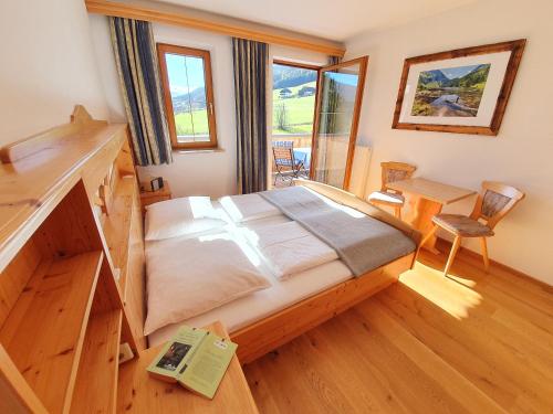ein Schlafzimmer mit einem Bett und einem Schreibtisch in einem Zimmer in der Unterkunft Ferienwohnungen Haus-Holzer in Mauterndorf