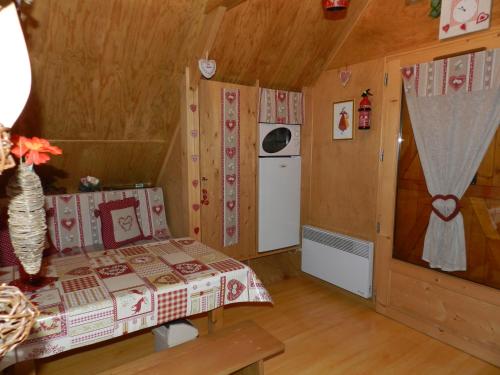 a small bedroom with a bed and a refrigerator at Gîte et Chambre D'hôte in Saint-Just-de-Claix