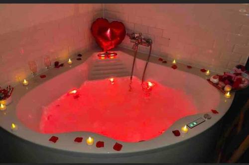 une baignoire remplie de sang rouge avec un cœur dedans dans l'établissement Charmant chalet jungle avec balneo, à Arthon