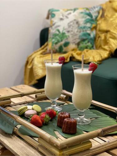 deux verres de lait et des fraises sur une table dans l'établissement Charmant chalet jungle avec balneo, à Arthon