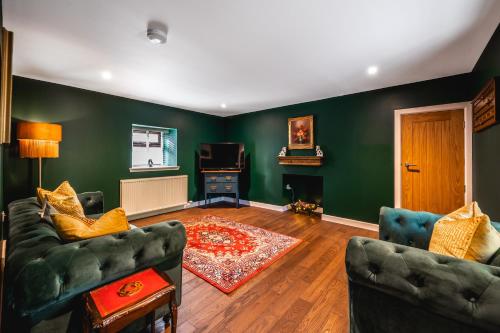 a living room with green walls and two couches at Luxury Cottage with Mountain View’s in Cononbridge