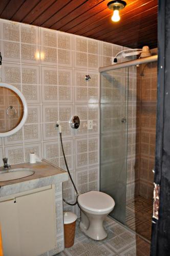 a bathroom with a toilet and a glass shower at Fortaleza Flat Executivo in Fortaleza