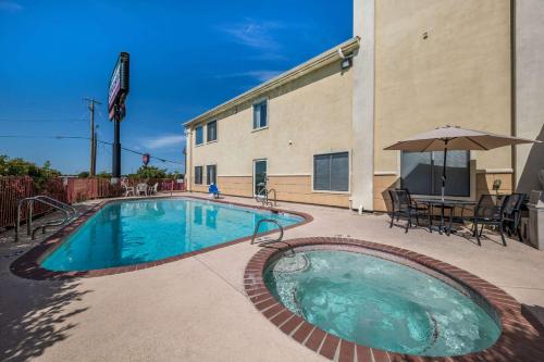 a swimming pool in front of a building at Quality Inn and Suites Terrell in Terrell