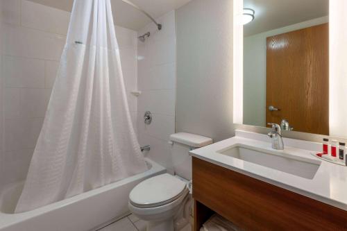 Baño blanco con aseo y lavamanos en Microtel Inn & Suites by Wyndham Sunbury - Columbus North, en Sunbury
