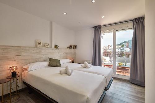 a bedroom with two beds and a large window at BBarcelona El Carmel Apartment with terrace in Barcelona