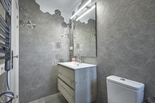 a bathroom with a sink and a toilet and a mirror at BBarcelona El Carmel Apartment with terrace in Barcelona
